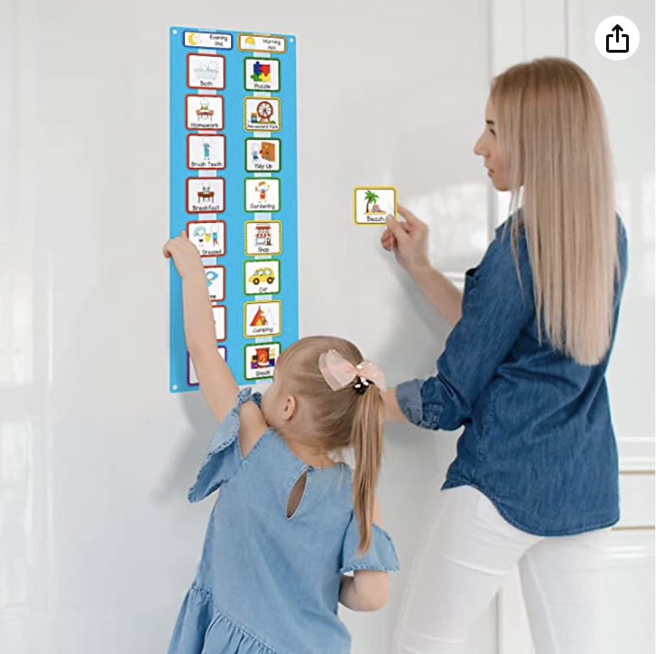 Mother and daughter making adjustments to a visual felt schedule hanging on the wall