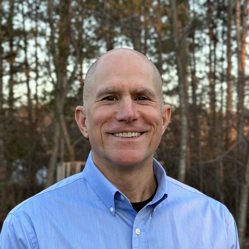 Mitch Leppicello standing in front of trees at dusk.